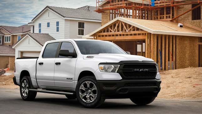 A photo of a white Ram 1500 pickup truck on a building site. 