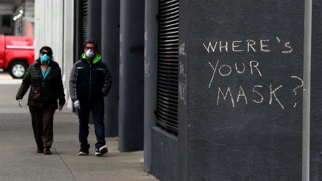 Pedestrians walk by graffiti encouraging the wearing of masks on April 20, 2020 in San Francisco, California.