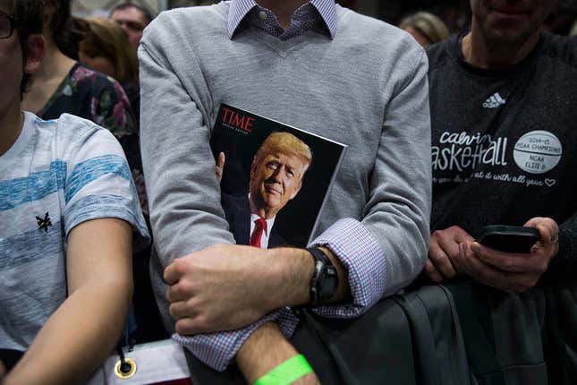 A member of the crowd holds a copy of Time magazine as President-elect Donald Trump speaks at the DeltaPlex Arena, December 9, 2016 in Grand Rapids, Michigan. 
