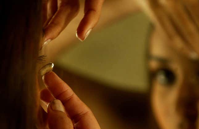 Model Amruta Patki puts in her contact lenses as she prepares for a show on the penultimate day of the Lakme Fashion Week in Mumbai, India, Friday, March 30, 2007.