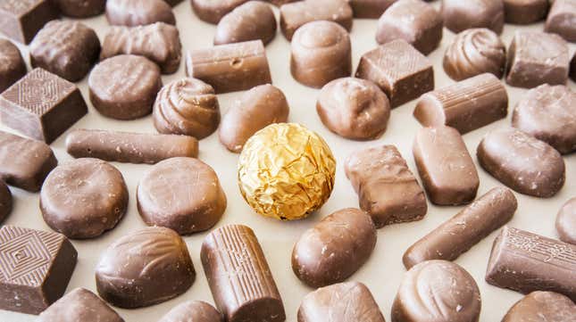 Gold-wrapped chocolate truffle surrounded by unwrapped chocolate