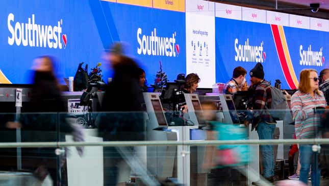 Travelers walk past the Southwest Airlines check-in counter at Denver International Airport on December 28, 2022 in Denver, Colorado. More than 15,000 flights have been canceled by airlines since winter weather began impacting air travel on December 22.