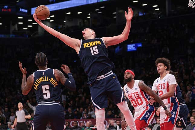 Mar 19, 2023; Brooklyn, New York, USA; Denver Nuggets center Nikola Jokic (15) rebounds in front of guard Kentavious Caldwell-Pope (5) and Brooklyn Nets forward Royce O&#39;Neale (00) and forward Cameron Johnson (2)  during the second half at Barclays Center.