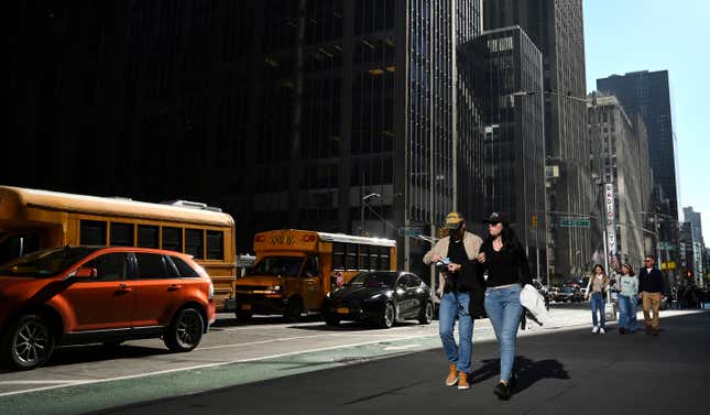 People walk down 6th Ave in Manhattan during unseasonably warm weather on November 2, 2022.