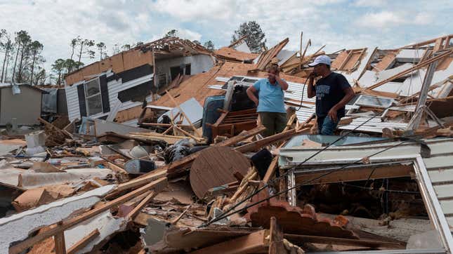 A couple react as they go through their destroyed mobile home following the passing of hurricane Laura in Lake Charles, Louisiana, on August 27, 2020. The same area is set to be hit by Hurricane Delta on Friday.
