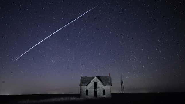 A streak of SpaceX StarLink satellites passes over an old stone house in Kansas.