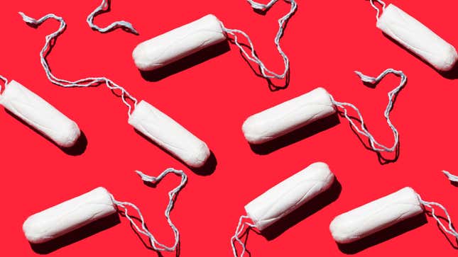A number of unfurled white tampons are placed artistically against a red background.