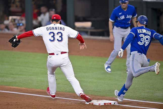 Jun 17, 2023; Arlington, Texas, USA; Texas Rangers starting pitcher Dane Dunning (33) puts out Toronto Blue Jays center fielder Kevin Kiermaier (39) at first base during the third inning at Globe Life Field.