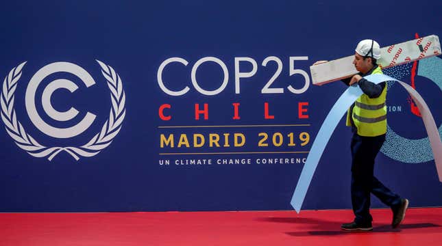 A worker walks past a COP 25 logo at IFEMA Convention Center, ahead of the 2019 U.N. climate change conference (COP 25) in Madrid