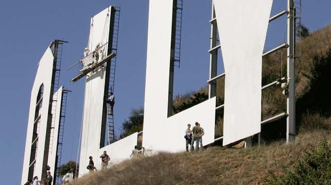 Painters with Bay Cal Commercial Painting work on the first “L” as the news media observes the repainting of the iconic Hollywood Sign November 16, 2005 in Hollywood, California. The 45-foot high letters of the famous sign, last painted in 1995, will receive a coat of primer and specially formulated paint called Hollywood White.