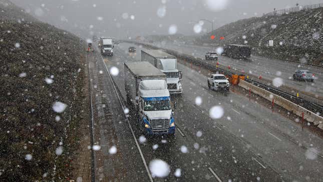 Snow flurries fall while tractor trailers and automobiles travel along Interstate 5 at the Tejon Pass along the Grapevine on Thursday, Feb. 23, 2023 in Tejon Pass, CA.