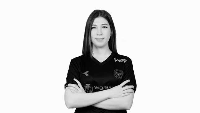 Gizem 'Luie' Harmankaya, a female esports player, stands against a white background with her arms folded in a black and white portrait.