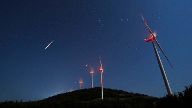 A meteor streaks across the sky during the Perseid meteor shower at a windmill farm near Bogdanci, Macedonia.