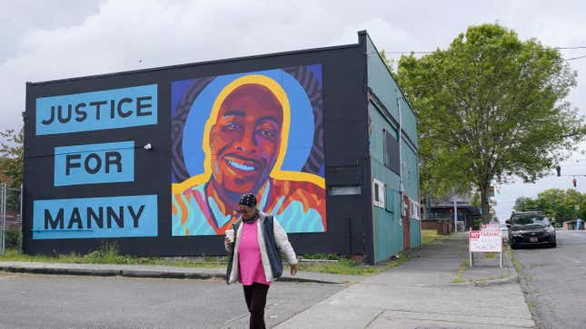 A woman walks past a mural honoring Manuel “Manny” Ellis, Thursday, May 27, 2021, in the Hilltop neighborhood of Tacoma, Wash., south of Seattle. Ellis died on March 3, 2020 after he was restrained by police officers. Earlier in the day Thursday, the Washington state attorney general filed criminal charges against three police officers in the death of Ellis, who told the Tacoma officers who were restraining him he couldn’t breathe before he died.