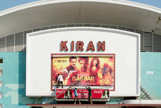 Three men work on the marquee of Kiran Cinema, Chandigarh.