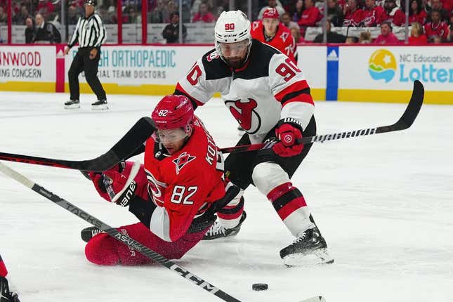 May 3, 2023; Raleigh, North Carolina, USA; Carolina Hurricanes center Jesperi Kotkaniemi (82) and New Jersey Devils left wing Tomas Tatar (90) battle over the puck during the first period in game one of the second round of the 2023 Stanley Cup Playoffs at PNC Arena.