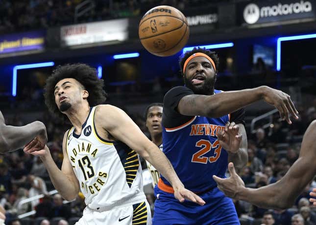 Apr 5, 2023; Indianapolis, Indiana, USA;  New York Knicks center Mitchell Robinson (23) knocks a rebound away from Indiana Pacers forward Jordan Nwora (13) during the first half at Gainbridge Fieldhouse.