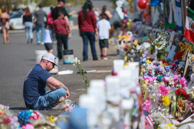 People gather at a makeshift memorial honoring victims of mass shootings in Texas.
