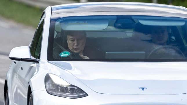 Tesla CEO Elon Musk uses his mobile device as he sits in the car arriving to the construction site for the new plant, the so-called “Giga Factory”, of US electric carmaker Tesla in Gruenheide near Berlin, northeastern Germany. - The site still has only provisional construction permits, but Tesla has been authorized by local officials to begin work at its own risk. Tesla is aiming to produce 500,000 electric vehicles a year at the plant, which will also be home to “the largest battery factory in the world”, according to group boss Elon Musk. (Photo by Odd ANDERSEN)