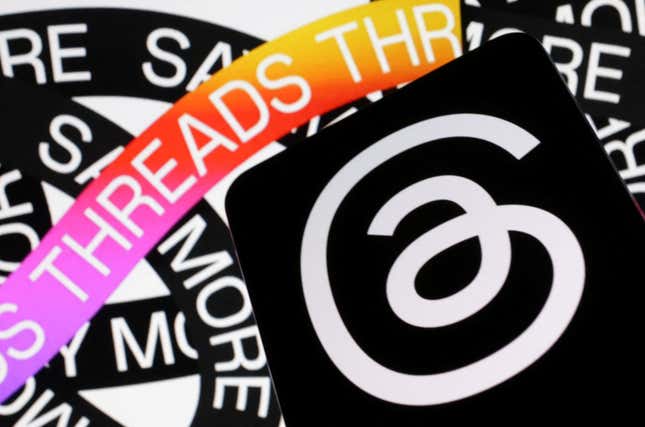 The Threads logo, a stylized "@" symbol is pictured on a phone, with the words "Threads" repeated on a looping design in the background.
