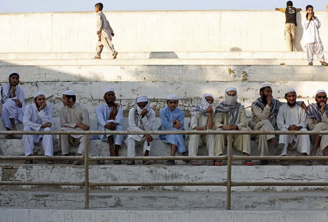 Students of a madrasa (religious school) gather to watch.