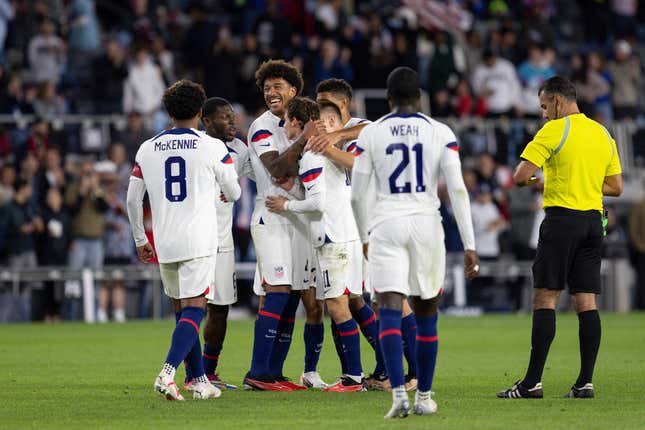 Team USA celebrates a Brenden Aaronson goal against Oman yesterday.