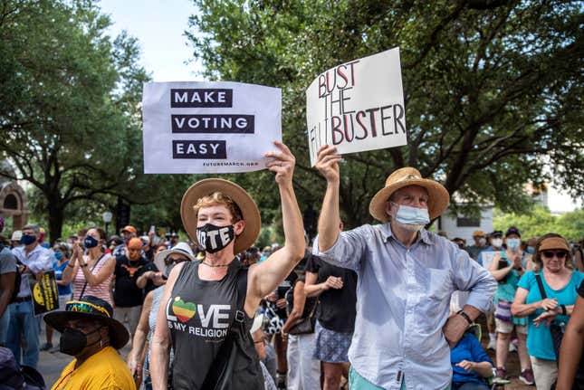 Attendees hold up signs during the final day of the Georgetown to Austin March for Democracy on Friday, July 31, 2021, in Austin, TX. 