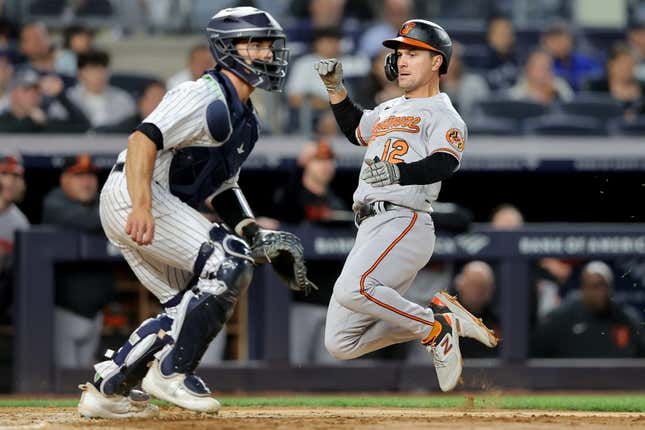 May 25, 2023; Bronx, New York, USA; Baltimore Orioles second baseman Adam Frazier (12) scores in front of New York Yankees catcher Ben Rortvedt (38) on an RBI single by Orioles right fielder Anthony Santander (not pictured) during the fifth inning at Yankee Stadium.
