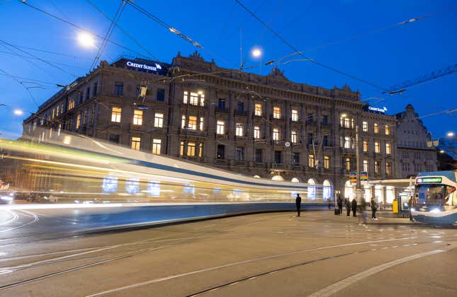 A long exposure shows a tram driving past the global headquarters of Swiss bank Credit Suisse.