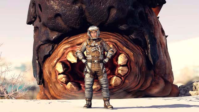 A screenshot shows a giant worm behind a person in a space suit. 