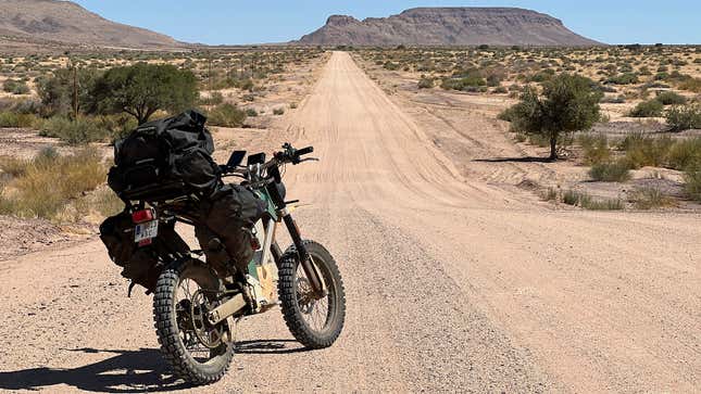 未舗装の道路を走るケーキのバイクの写真。 