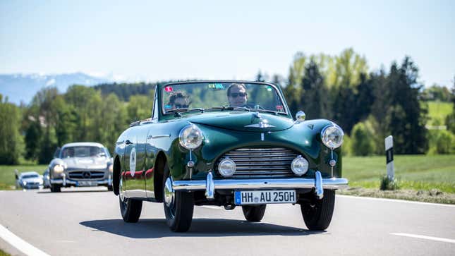 A green convertible drives on an open road 