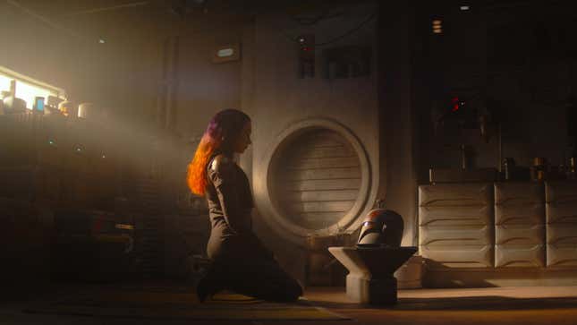 Sabine Wren kneels in front of her Mandalorian helmet in Ezra's Tower.