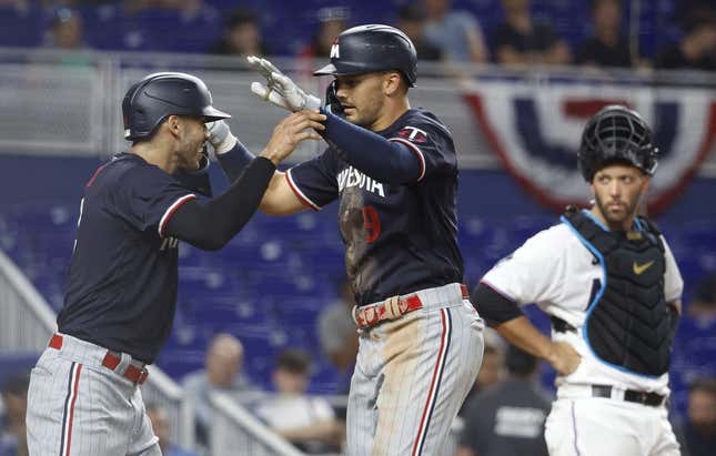 Apr 3, 2023; Miami, Florida, USA;  Miami Marlins catcher Jacob Stallings (58) watches Minnesota Twins left fielder Trevor Larnach (9) and shortstop Carlos Correa celebrate (4) after a two-run home run during the seventh inning at loanDepot Park.