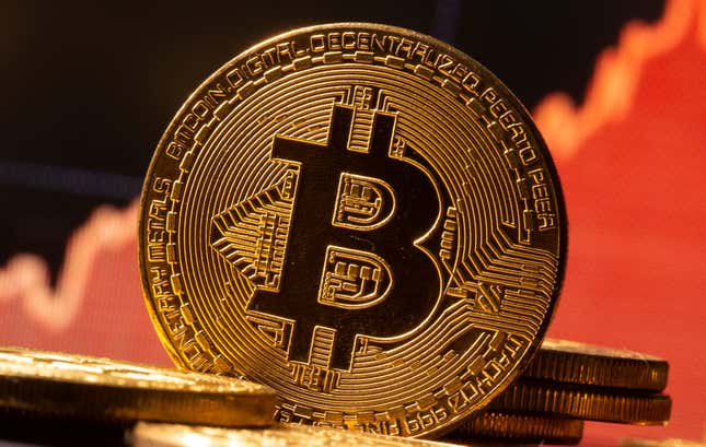 A representation of virtual currency Bitcoin is seen in front of a stock graph