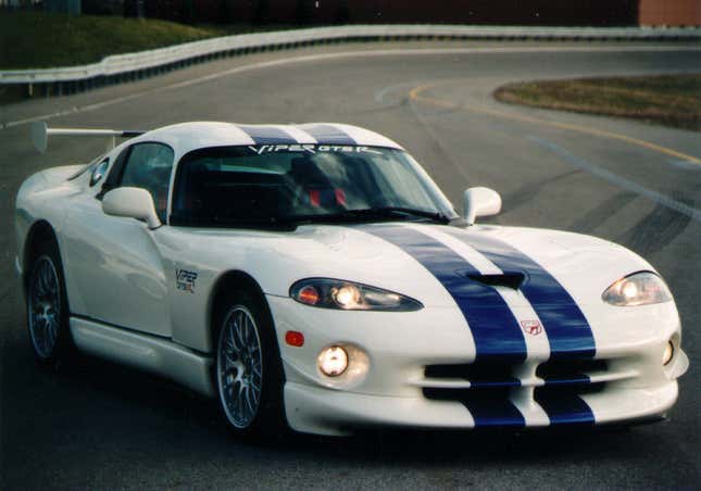 A Dodge Viper GTS-R Coupe in white with twin blue stripes is parked on a race track