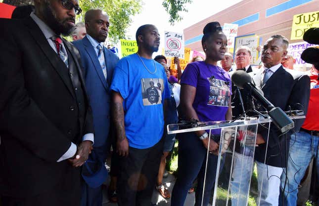 Delisha Searcy, mother of De’Von Bailey, at podium, speaks at a news conference in front of the Colorado Springs Police Department Police Operations Center in Colorado Springs, Colo., on Aug. 13, 2019. Greg Bailey, third from left, De’Von Bailey’s father, stands next to Searcy.
