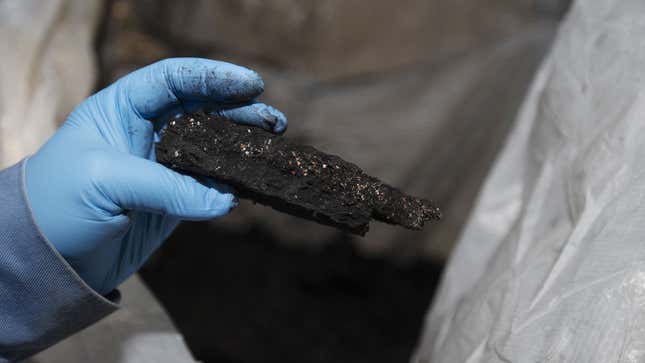 A photo of someone holding a chunk of black mass from the Li-Cycle factory. 