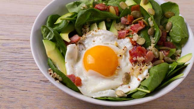 salad with spinach, fried egg, bacon, avocado, and couscous