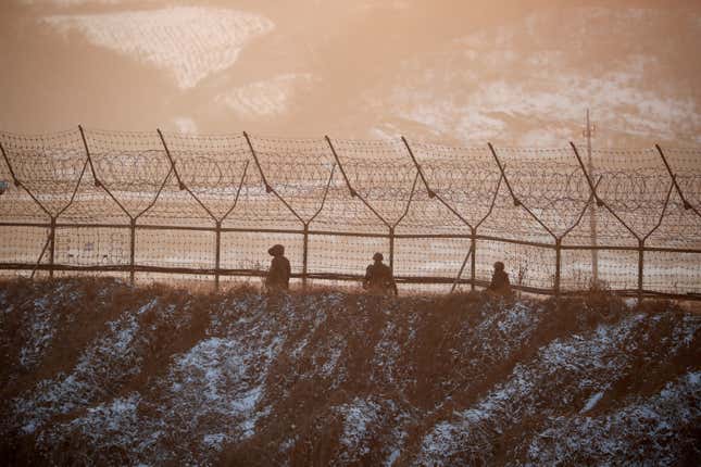 South Korean soldiers patrol along a barbed-wire fence near the demilitarized zone separating the two Koreas, in Paju, South Korea, December 21, 2017.