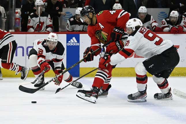 Apr 1, 2023; Chicago, Illinois, USA;  New Jersey Devils left wing Erik Haula (56) and New Jersey Devils center Dawson Mercer (91) chase the puck against Chicago Blackhawks defenseman Seth Jones (4) during the first period at the United Center.