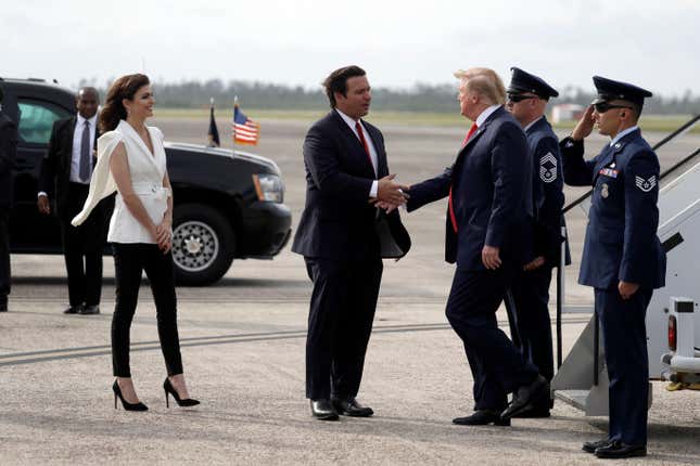 President Donald Trump shakes hands with Florida Gov. Ron DeSantis as he arrives at Tyndall Air Force Base to view damage from Hurricane Michael, and attend a political rally, Wednesday, May 8, 2019, at Tyndall Air Force Base, Fla. His wife, Casey DeSantis watches at left.