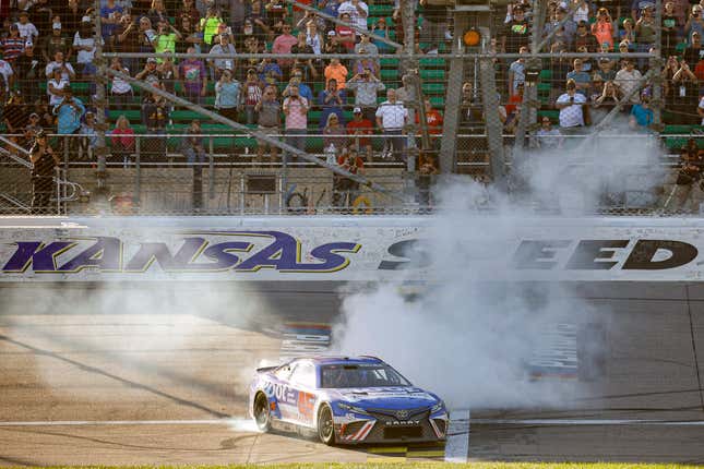 Bubba Wallace, driver of the No. 45 ROOT Insurance Toyota, celebrates with a burnout after winning the NASCAR Cup Series Hollywood Casino 400 at Kansas Speedway on September 11, 2022 in Kansas City, Kansas. 