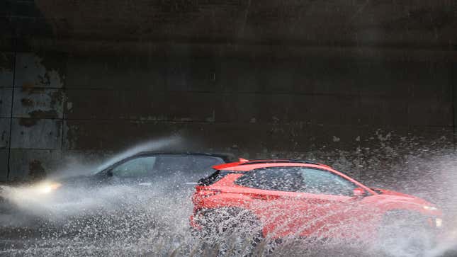 Two cars drive through puddles in New York City