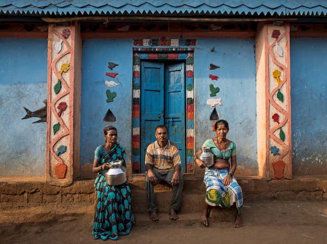 Namdeo poses with his wives Shivarti (L) and Bagabai (R) outside their house