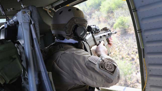 A U.S. Customs and Border Protection (CBP) agent aims his weapon from a Black Hawk helicopter while pursuing a truck with suspected undocumented immigrants on February 21, 2018 in McAllen, Texas.