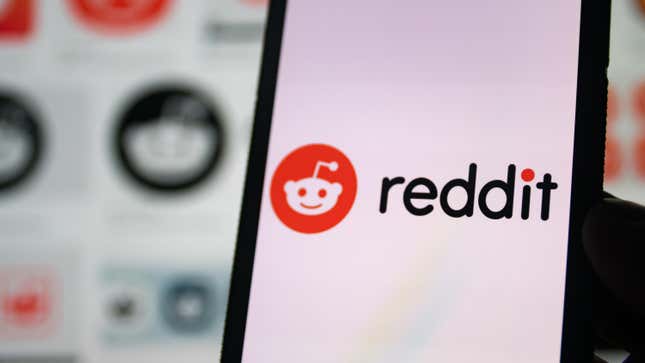 Reddit logo on the phone in front of a background of more reddit logos