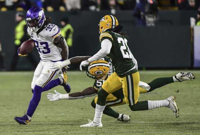 Jan 2, 2022; Green Bay, Wisconsin, USA; Minnesota Vikings running back Dalvin Cook (33) tries to break a tackle by Green Bay Packers linebacker Krys Barnes (51) in the first quarter at Lambeau Field.