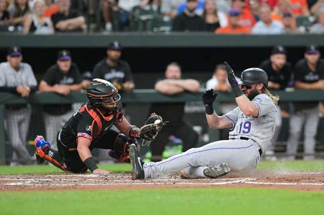 25. August 2023;  Baltimore, Maryland, USA;  Der designierte Schlagmann der Colorado Rockies, Charlie Blackmon (19), rutscht am Baltimore Orioles-Fänger James McCann (27) vorbei und punktet im zweiten Inning im Oriole Park bei Camden Yards.