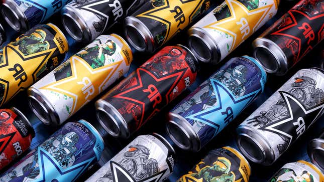 A bunch of cans of Rockstar energy drink with Halo branding on them lay down on a black background.